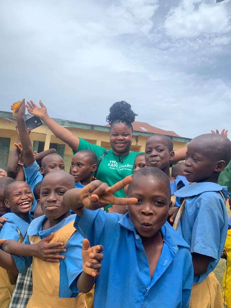 Children cheering with a member of our team outside a school in Lagos
